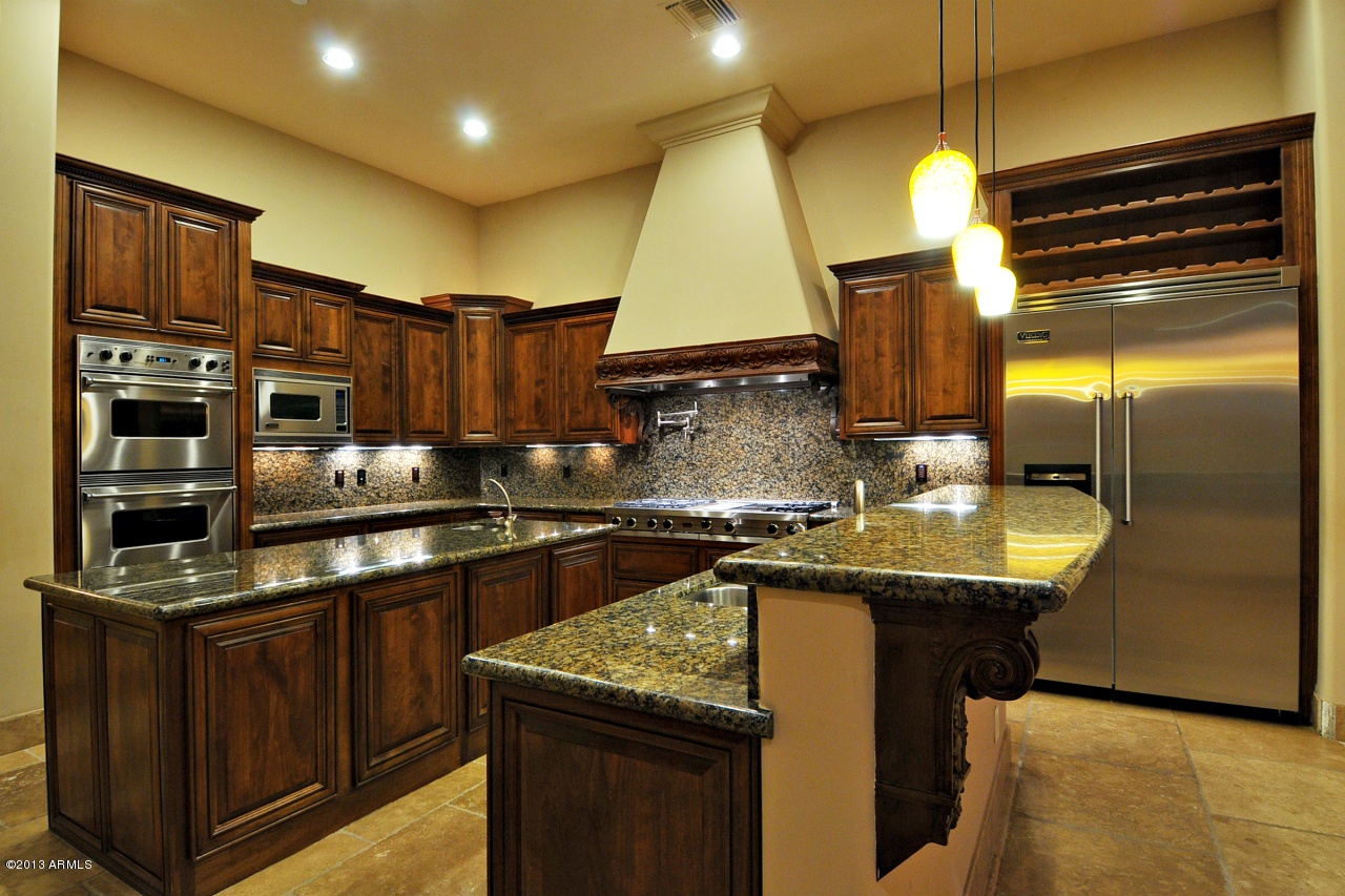12827 East Cibola Road Scottsdale, AZ 85259 - Photo 16 of 64 a kitchen with stainless steel appliances granite countertop a sink a stove and a wooden cabinets