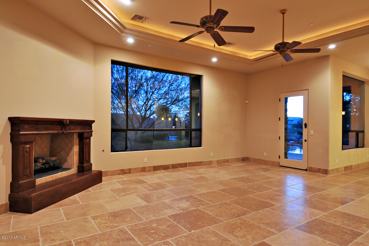 12827 East Cibola Road Scottsdale, AZ 85259 - Photo 25 of 64 a view of an empty room with a fireplace and a ceiling fan