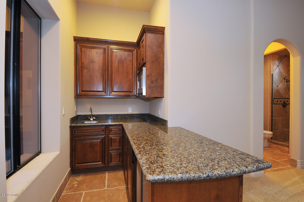 12827 East Cibola Road Scottsdale, AZ 85259 - Photo 52 of 64 a kitchen with granite countertop a sink and a stove top oven