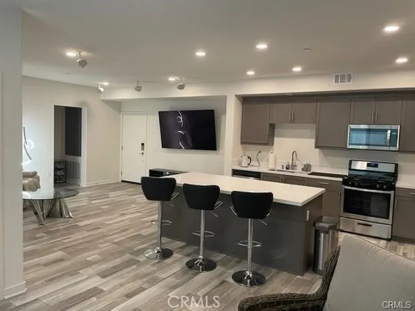 a kitchen with stainless steel appliances kitchen island granite countertop a sink and chairs