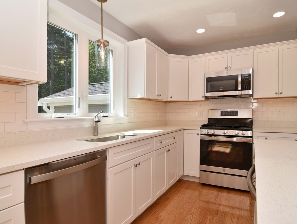 881 Maple Street Mansfield, MA 02048 - Photo 8 of 34 a kitchen with stainless steel appliances granite countertop a sink a stove and a microwave