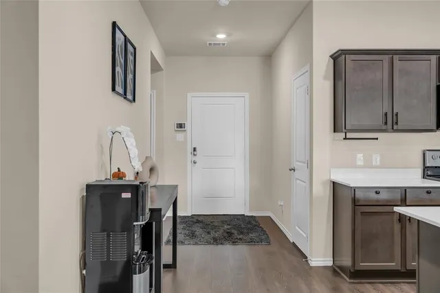 a kitchen with stainless steel appliances granite countertop a stove a sink a microwave a refrigerator and chairs