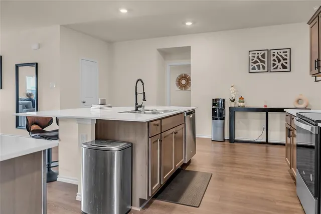 a kitchen with stainless steel appliances granite countertop a sink a stove a refrigerator and a refrigerator