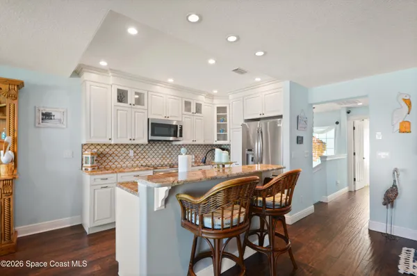 a kitchen with stainless steel appliances granite countertop a sink and a dining table