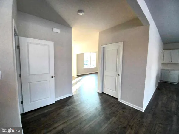 an empty room with wooden floor & windows