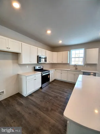 a large kitchen with stainless steel appliances granite countertop a stove a sink and a refrigerator