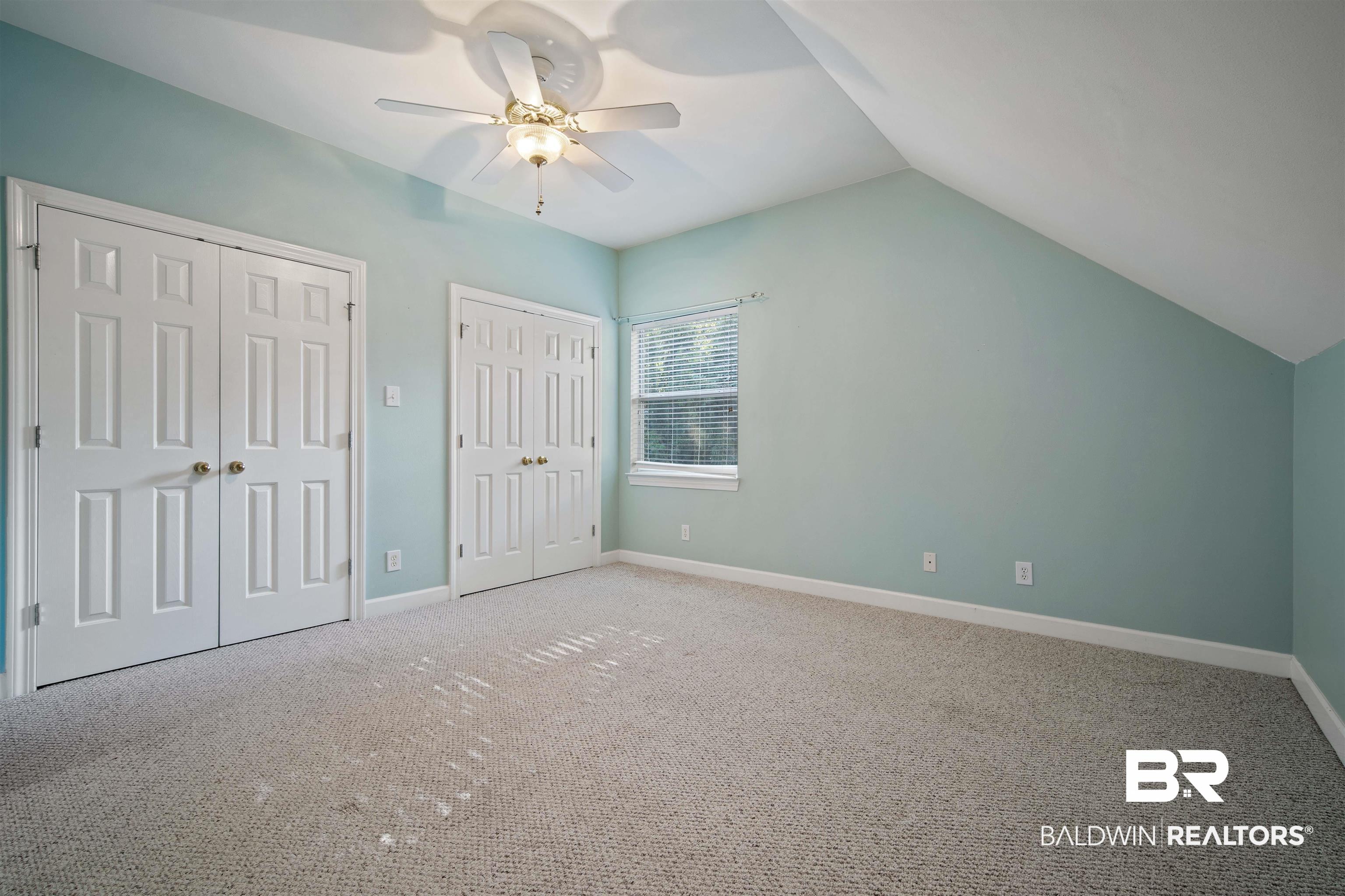 204 General Canby Loop Daphne, AL 36527 - Photo 25 of 36 Unfurnished bedroom with ceiling fan, multiple closets, lofted ceiling, and carpet