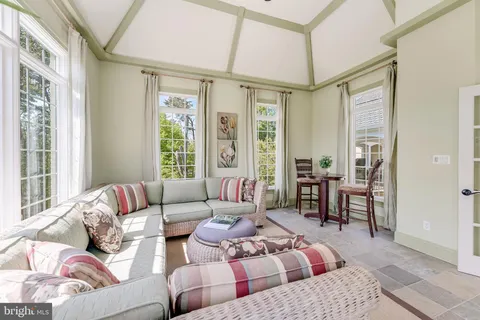 a living room with furniture a flat screen tv and floor to ceiling window
