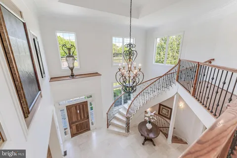 a view of hallway with stairs and wooden floor