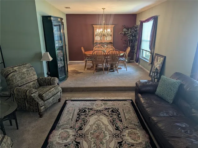 a view of a dining room with furniture and chandelier