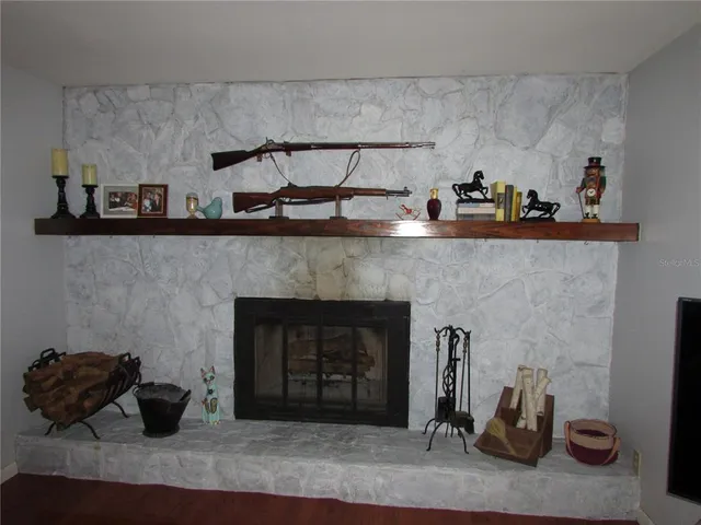 a large kitchen with stainless steel appliances a stove a sink dishwasher and a fireplace with wooden floor