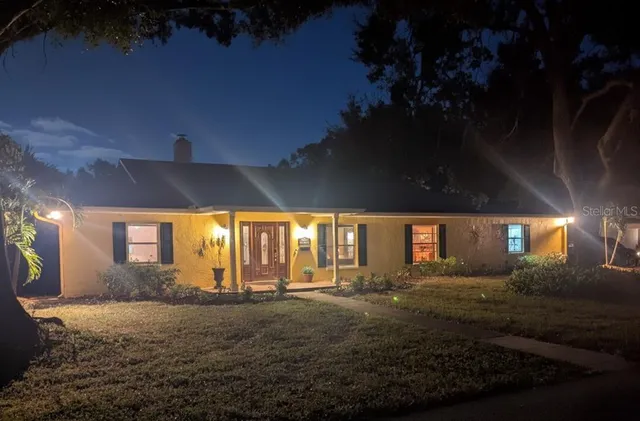 a view of an house with backyard and tree