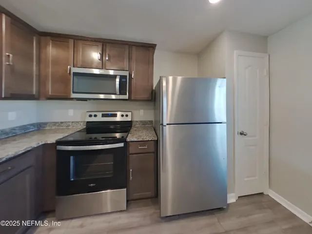 a kitchen with a refrigerator stove and microwave