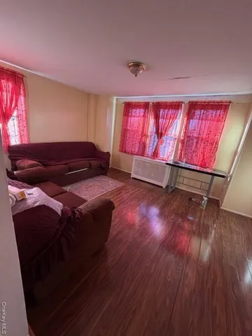 a bedroom with a bed window and wooden floor