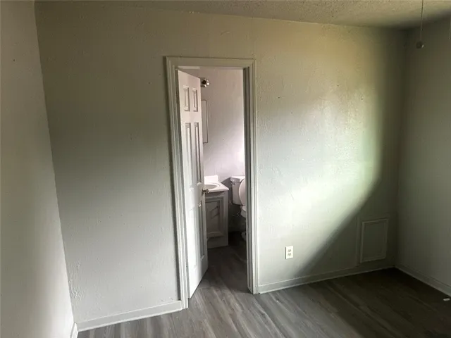 a view of a hallway with wooden floor and closet