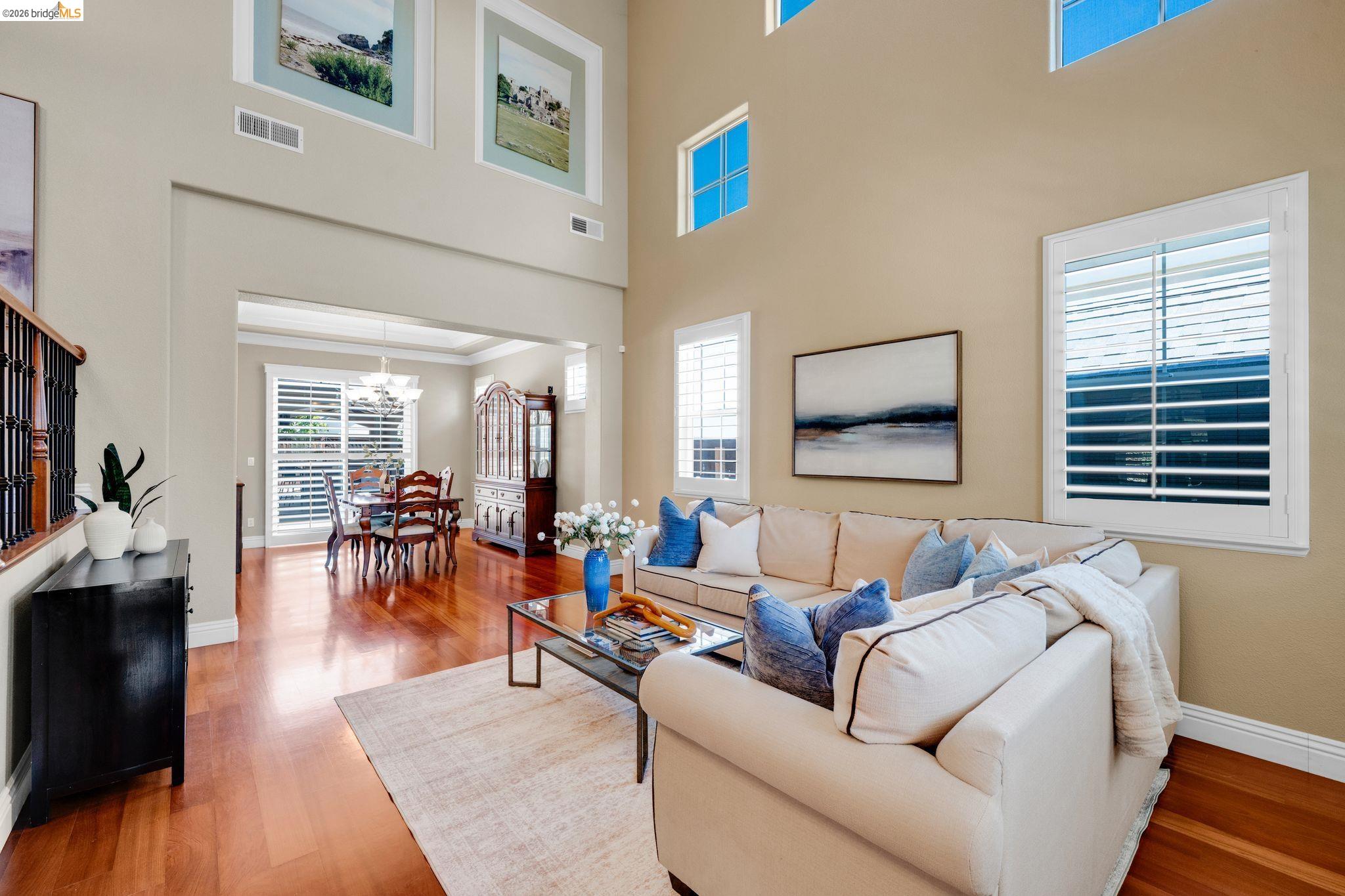 2513 Winged Foot Road Brentwood, CA 94513 - Photo 2 of 45 Spacious living area featuring high ceilings, rich wood-finish flooring, and multiple windows with plantation shutters