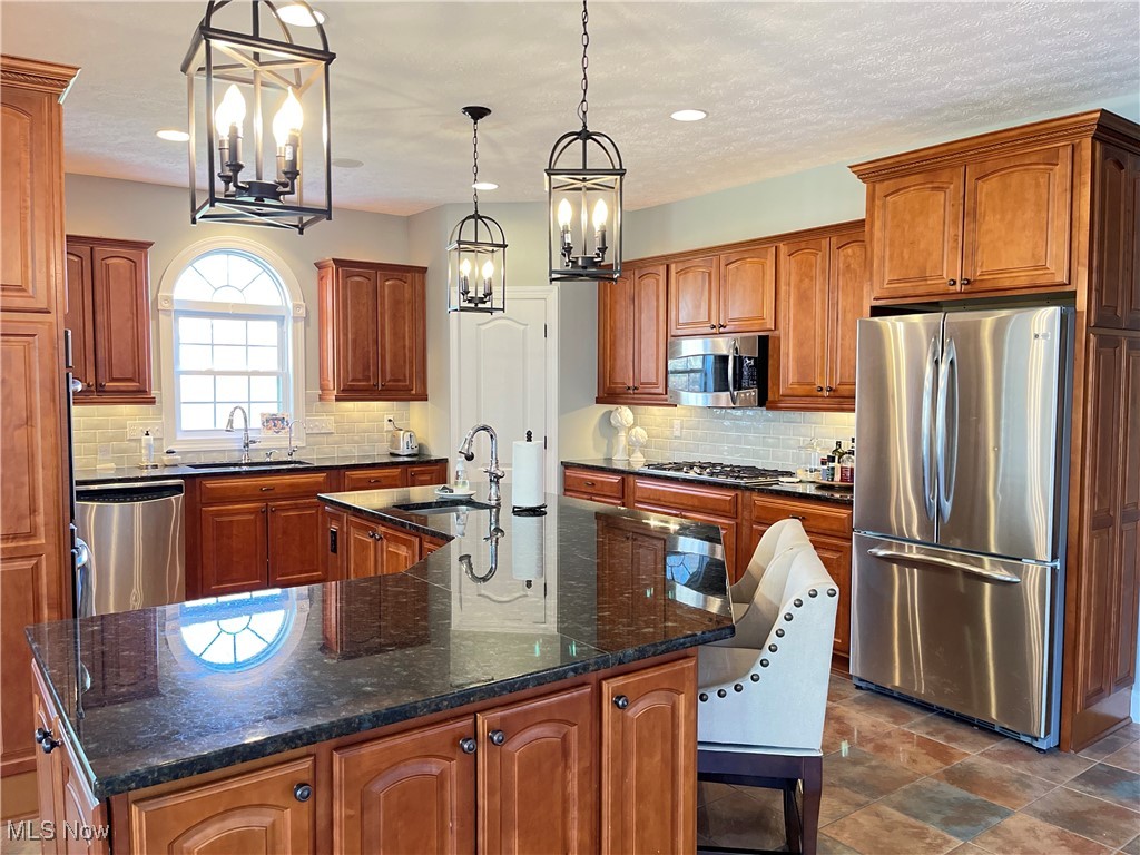 4679 Paxton Road Akron, OH 44321 - Photo 23 of 46 Kitchen with stainless steel appliances, a sink, a chandelier, a large island with sink, and recessed lighting