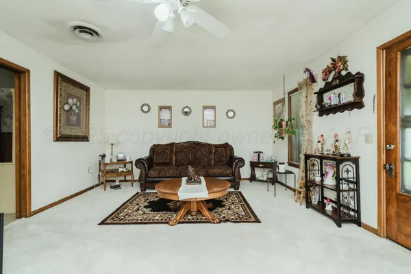 a living room with furniture a rug and white walls