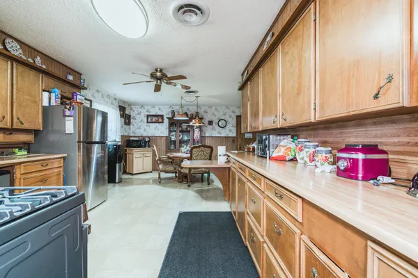 a kitchen with stainless steel appliances granite countertop a stove top oven a sink dishwasher and cabinets with wooden floor
