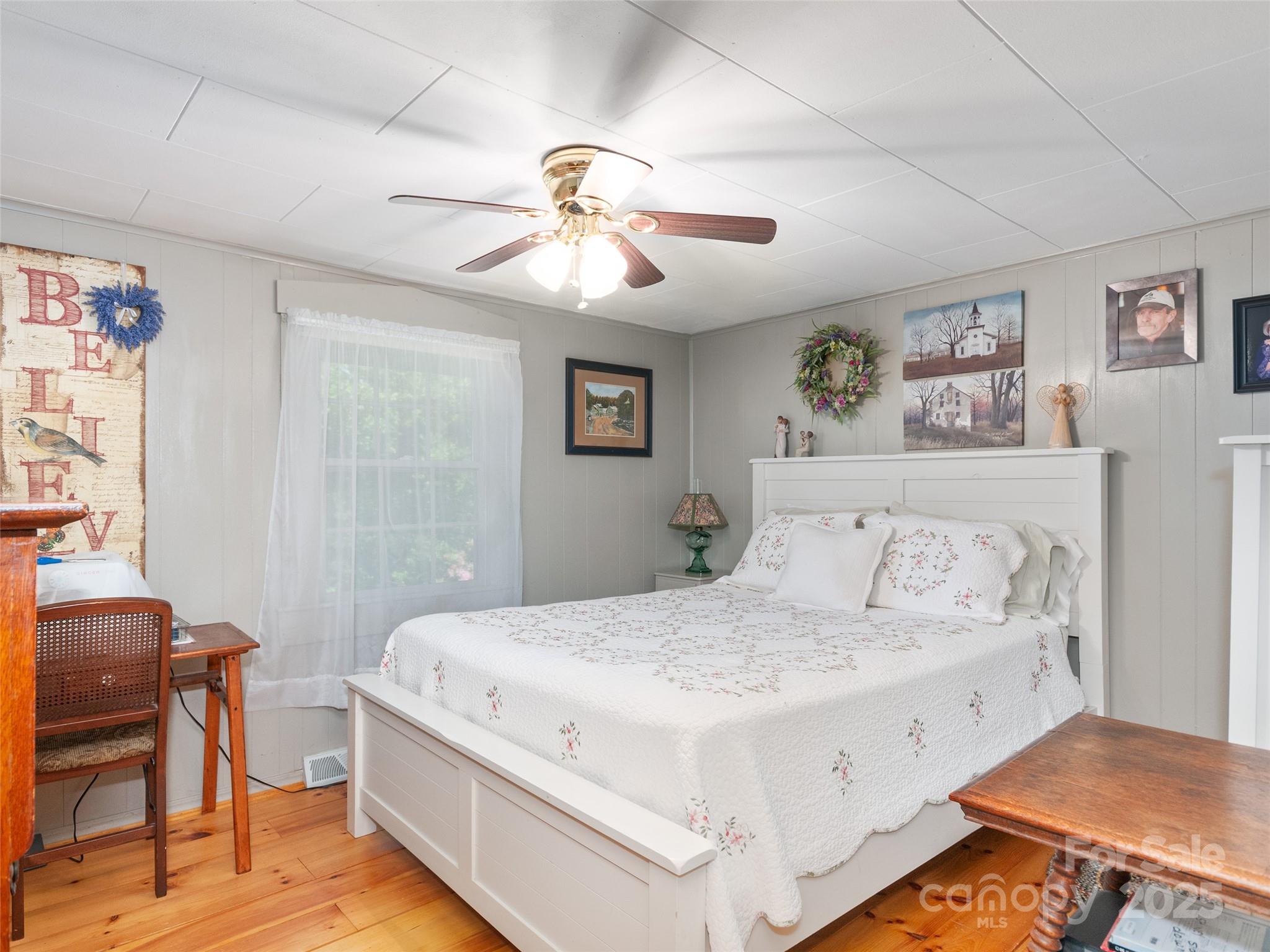 229 Crabtree Mountain Road Canton, NC 28716 - Photo 12 of 42 a bedroom with a large bed and a chandelier