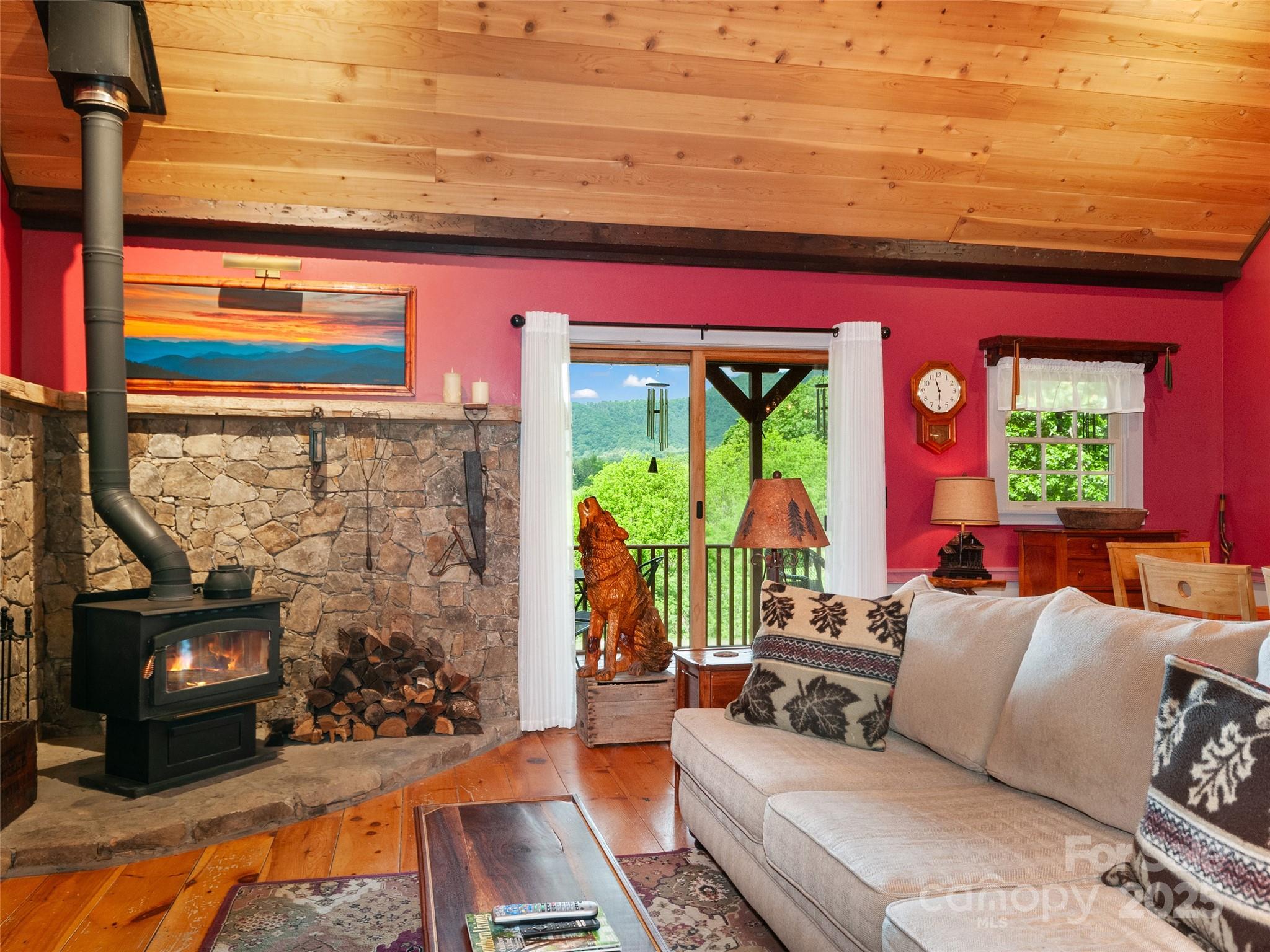 229 Crabtree Mountain Road Canton, NC 28716 - Photo 23 of 42 a living room with furniture a fireplace and a floor to ceiling window