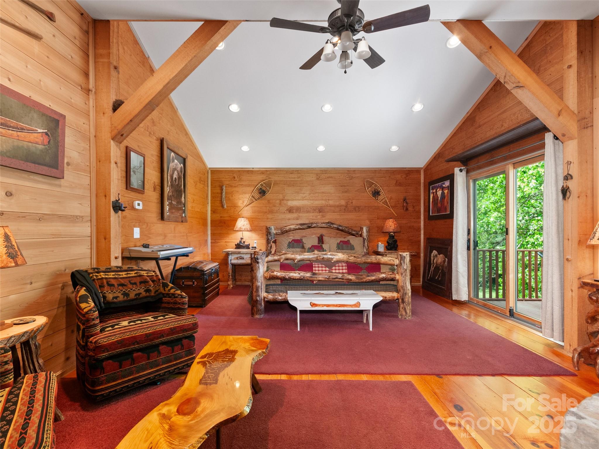 229 Crabtree Mountain Road Canton, NC 28716 - Photo 31 of 42 a living room with furniture a floor to ceiling window and a flat screen tv