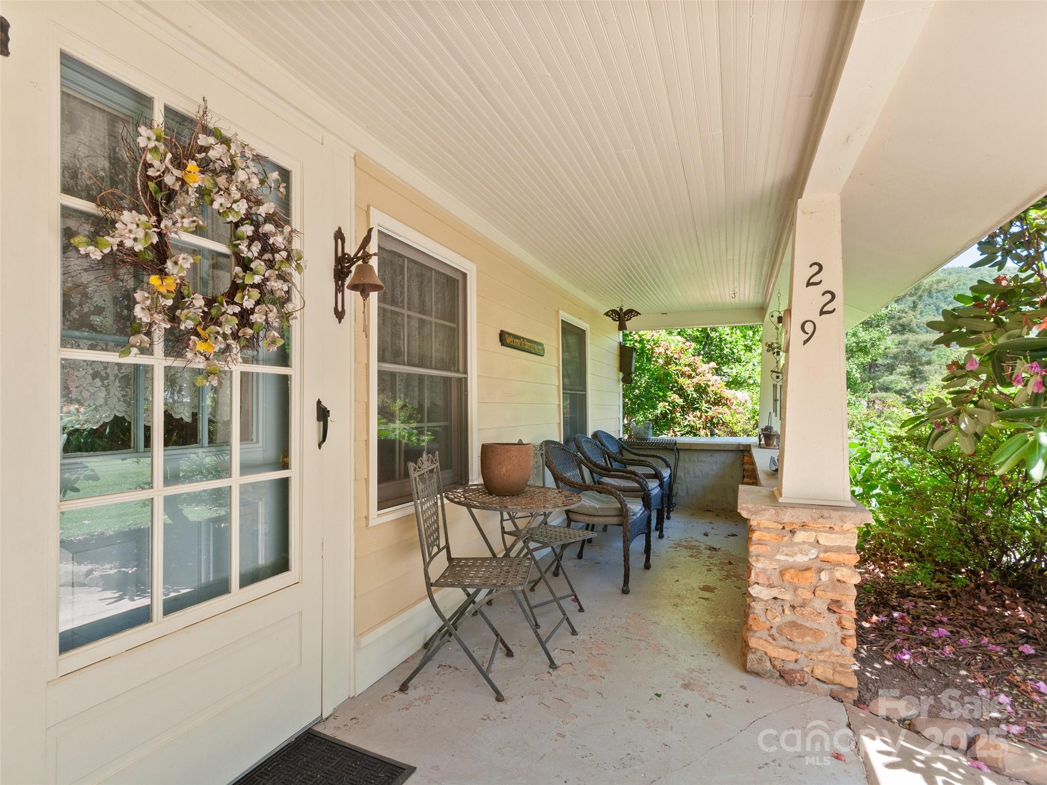 229 Crabtree Mountain Road Canton, NC 28716 - Photo 6 of 42 a view of a patio with table and chairs and potted plants