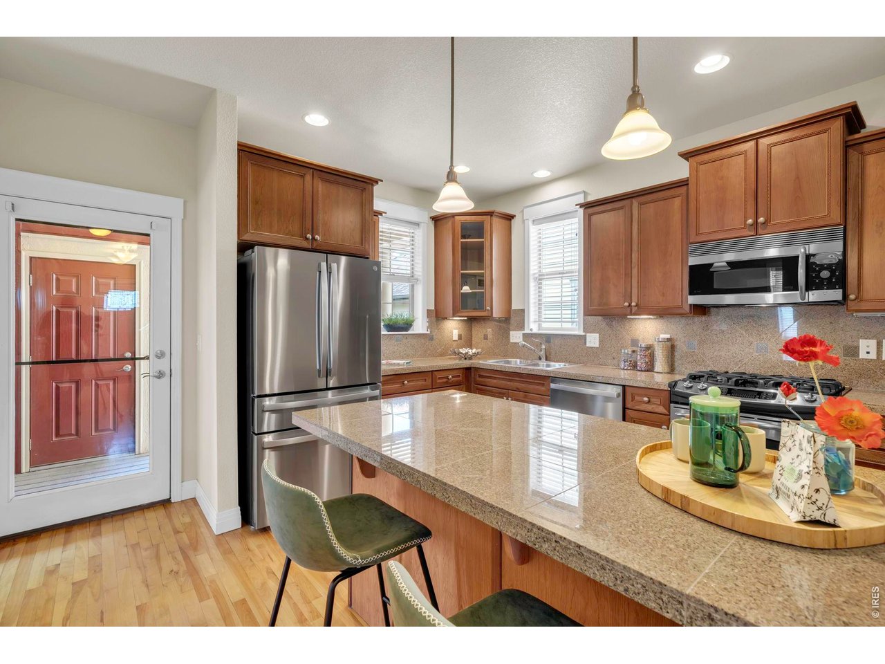 696 Homestead Street Lafayette, CO 80026 - Photo 19 of 49 a kitchen with stainless steel appliances granite countertop a refrigerator a stove a sink dishwasher and white cabinets with wooden floor