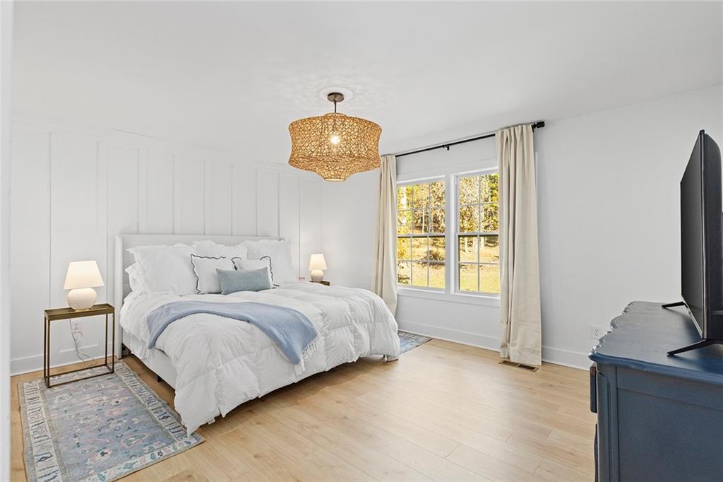 12005 Hamilton Road Chattahoochee Hills, GA 30268 - Photo 18 of 51 a spacious bedroom with a bed and a flat tv screen on dresser