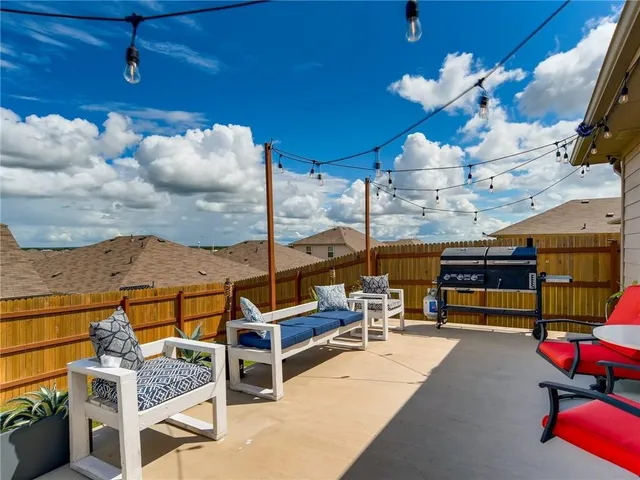 a living room with furniture a chandelier and a floor to ceiling window