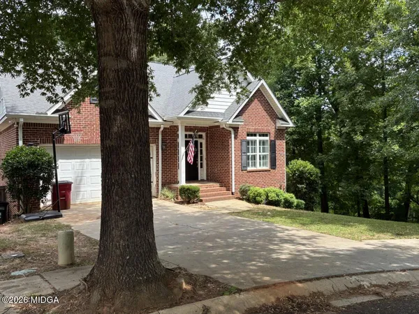 a front view of a house with a yard and potted plants