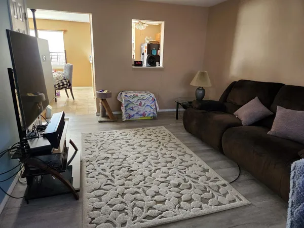 a living room with furniture a flat screen tv and a window