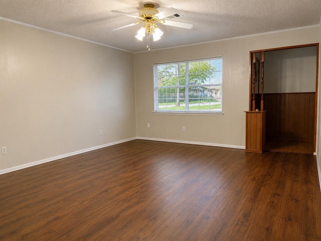 2111 Quail Run, Unit A McKinney, TX 75071 - Photo 4 of 12 an empty room with wooden floor fan and windows