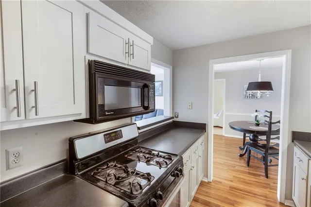 a kitchen with stainless steel appliances granite countertop a stove and a microwave