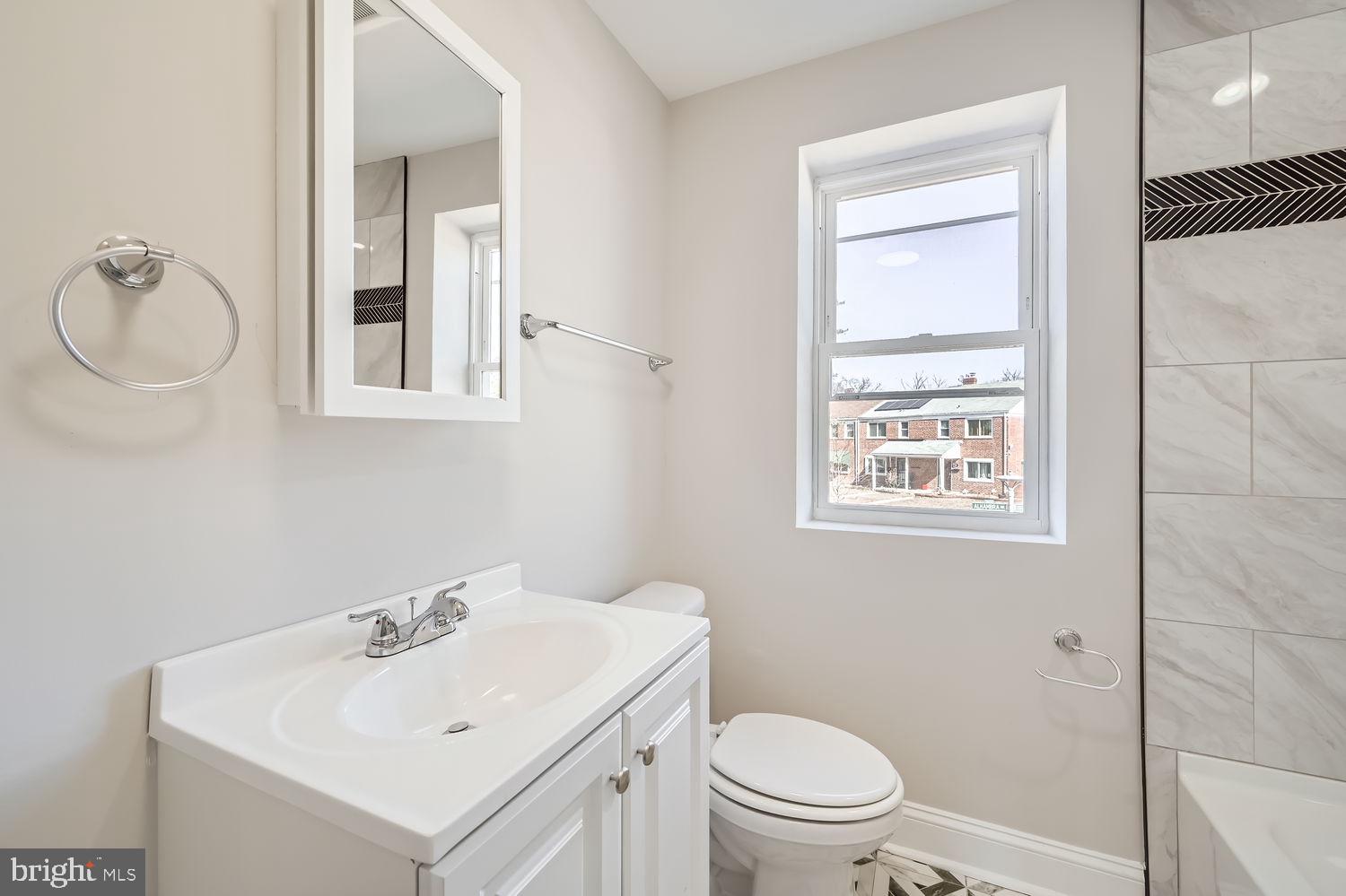 801 Bradhurst Road Baltimore, MD 21212 - Photo 16 of 26 a bathroom with a toilet sink vanity and mirror