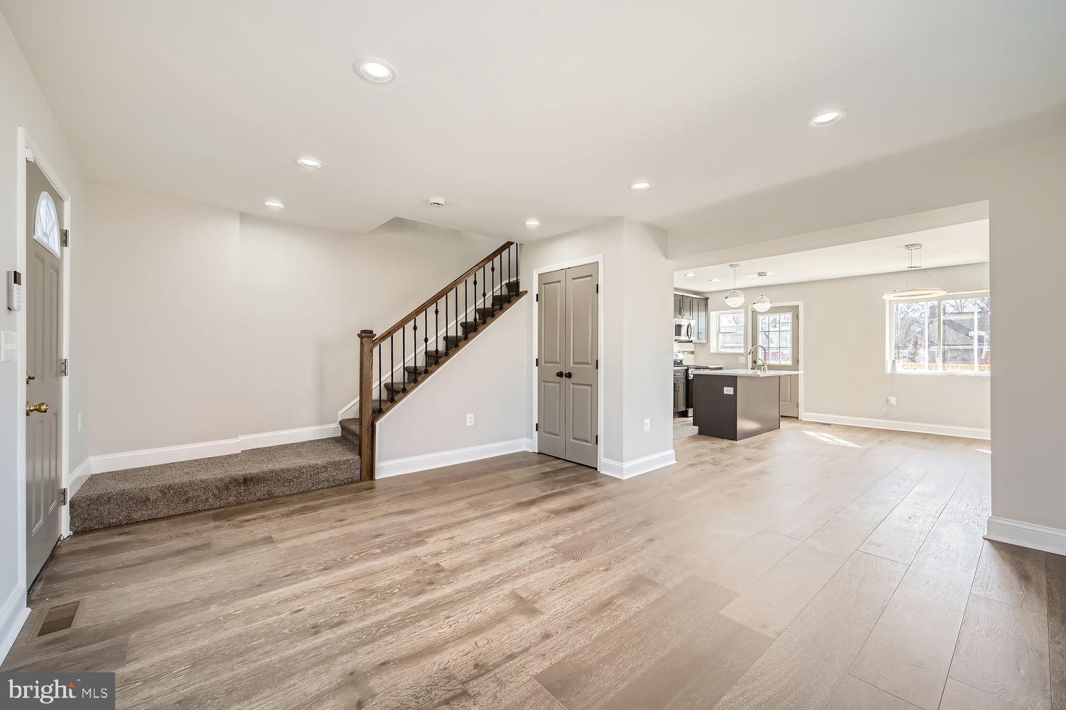801 Bradhurst Road Baltimore, MD 21212 - Photo 6 of 26 a view of an empty room with wooden floor kitchen view and a window