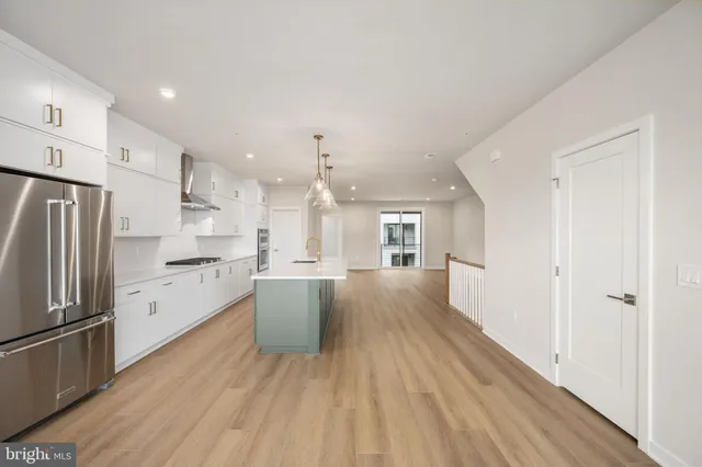a large kitchen with a lot of counter space and stainless steel appliances