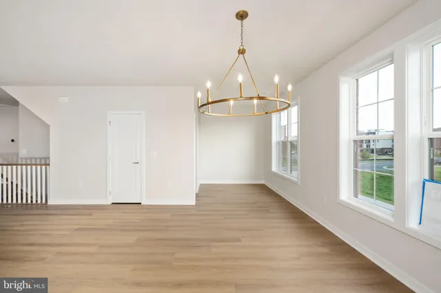 a view of a room with wooden floor chandeliers and staircase