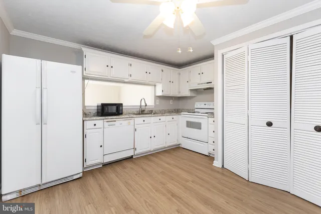 a kitchen with cabinets oven and a dishwasher with wooden floor