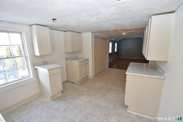 a kitchen with white cabinets and sink