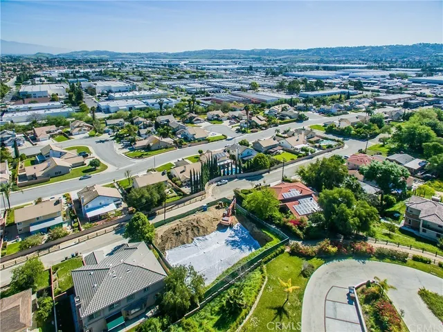 an aerial view of residential houses with outdoor space and trees
