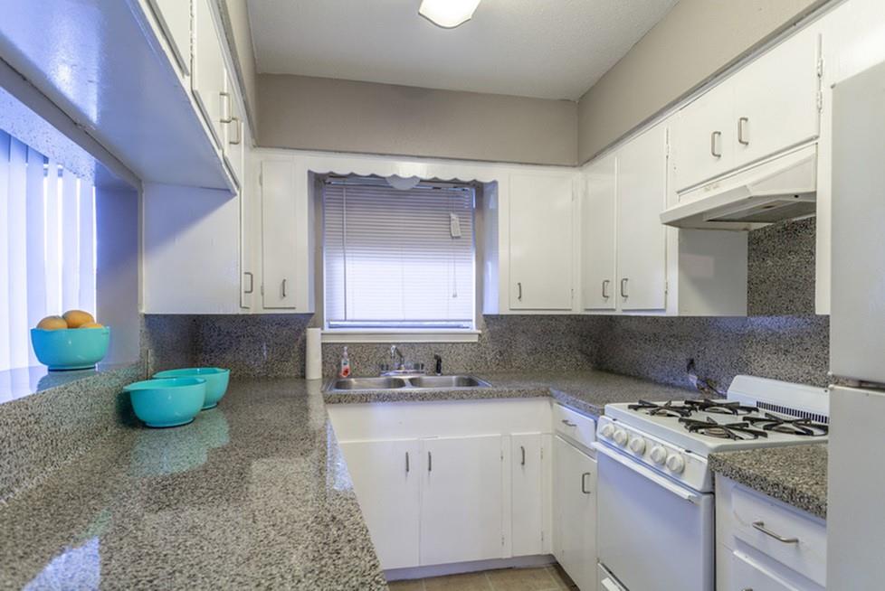 a kitchen with a stove a sink and a cabinets