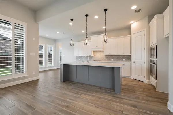 a large kitchen with kitchen island a sink stainless steel appliances and cabinets