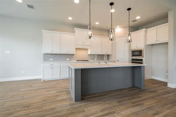 a kitchen with kitchen island a sink stainless steel appliances and cabinets