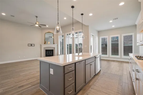 a kitchen with a sink chandelier and wooden floor