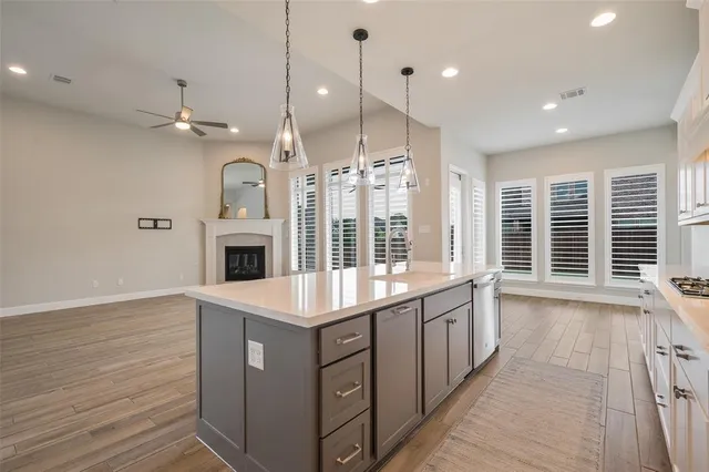 a kitchen with a sink chandelier and wooden floor