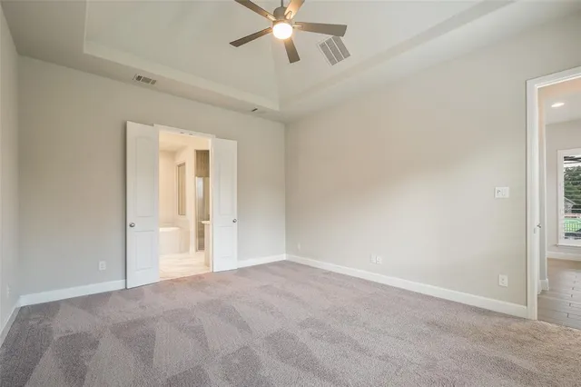 a view of an empty room and chandelier fan