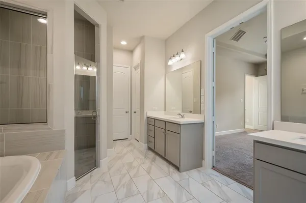 a bathroom with a tub sink and mirror
