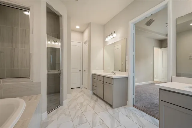 a bathroom with a tub sink and mirror