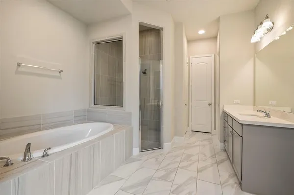 a spacious bathroom with a tub sink and mirror